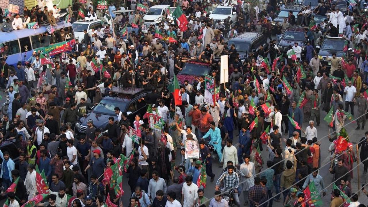 Supporters move with a convey of carrying Pakistan's former Prime Minister Imran Khan during an election campaign rally, in Lahore, Pakistan, Monday, March 13, 2023. Credit: AP/PTI