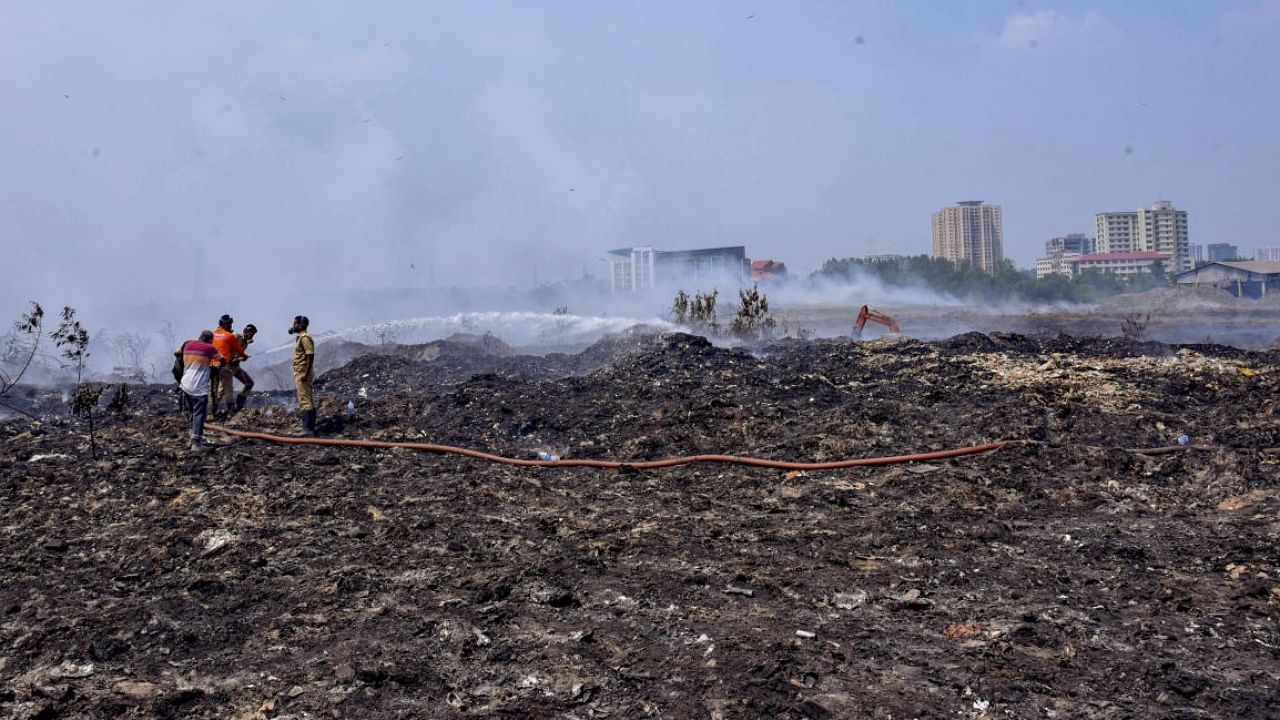 Fire and rescue personnel try to put out the fire which broke out at the Brahmapuram waste treatment plant, in Kochi, Sunday, March 5, 2023. Credit: PTI Photo