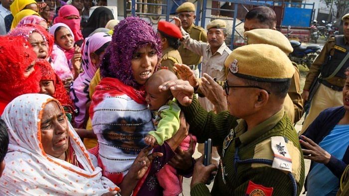 A policeman speaks with relatives of people arrested by police for their alleged involvement in child marriages. Credit: PTI Photo