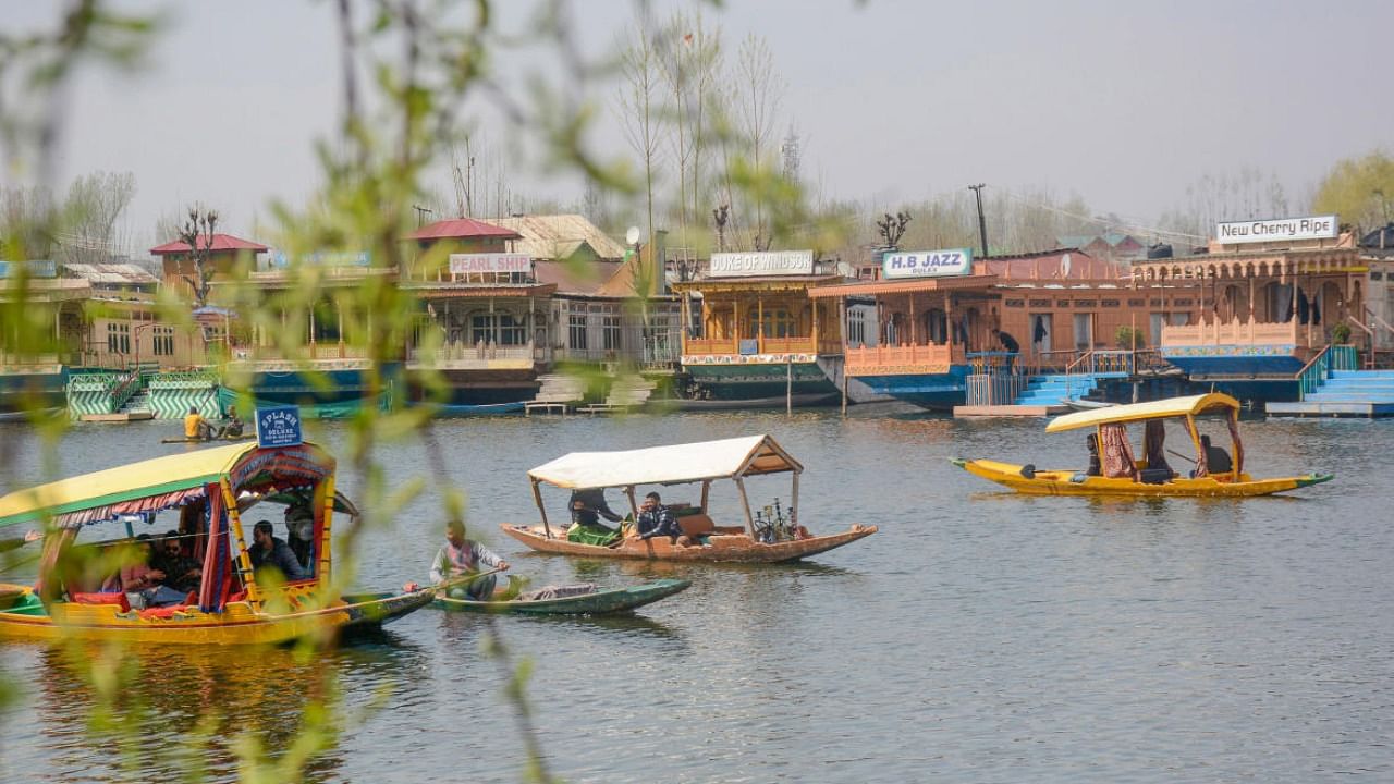 Tourists take a 'shikara' ride across the Dal Lake, in Srinagar. Credit: PTI File Photo