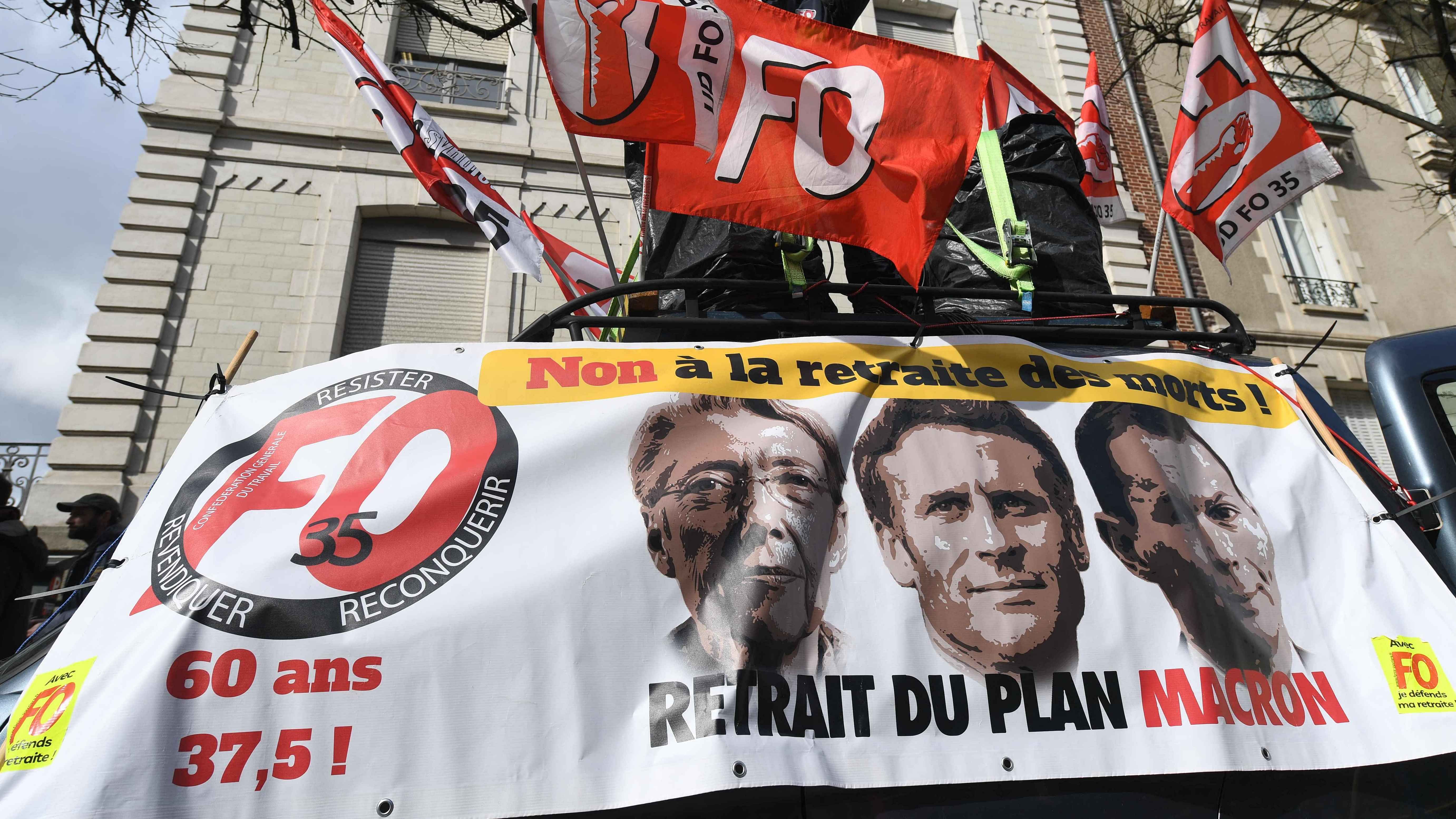 A protester speaks above a banner depicting (L-R) French Prime Minister Elisabeth Borne, French President Emmanuel Macron and French Labour Minister Olivier Dussopt reading "No to the retirement of the dead, withdrawal of Macron's plan" during a demonstration a day after the French government pushed a pensions reform through parliament without a vote, using the article 49.3 of the constitution, in Rennes, western France. Credit: AFP