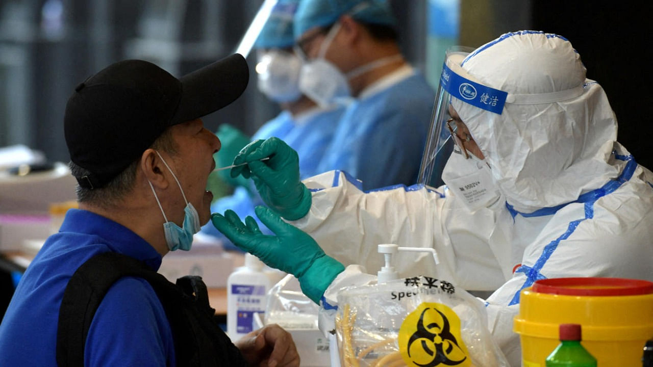 Medical staff collects swabs from people who have recently travelled to Beijing for nucleic acid tests, in Nanjing. Credit: Reuters Photo