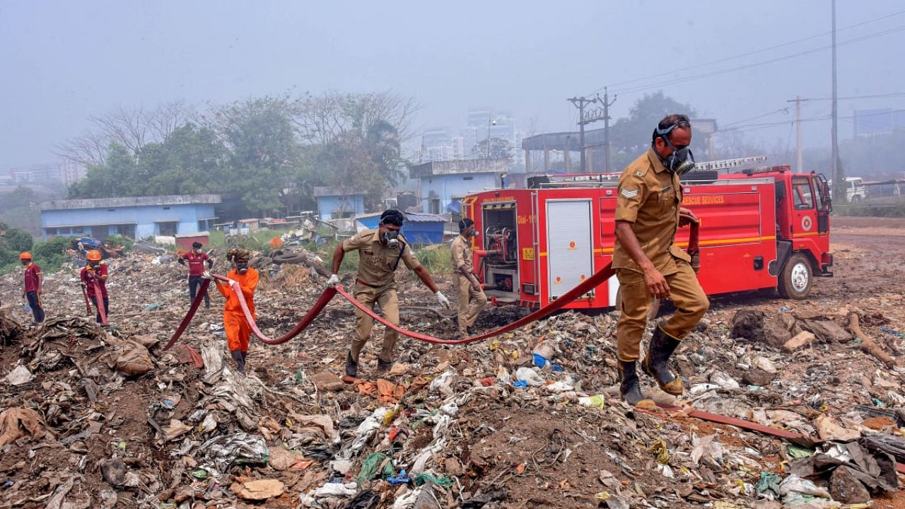 Fire and rescue personnel try to put out the fire which broke out at the Brahmapuram waste treatment plant. Credit: PTI Photo