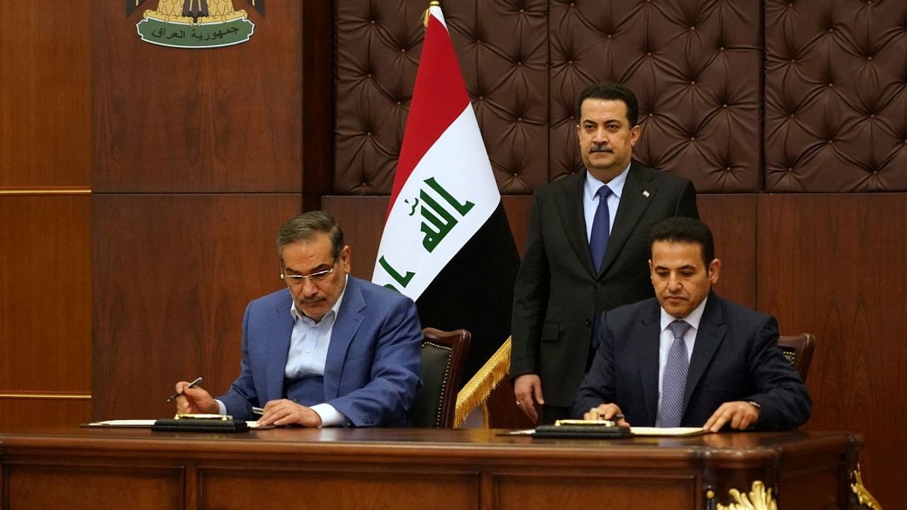 Iraqi Prime Minister Mohammed Shia al-Sudani looks on as Iraq's National Security Adviser Qasim al-Araji and Iran's Supreme National Security Council secretary Ali Shamkhani sign the security agreement that includes coordination in protecting the common borders between the two countries, in Baghdad, Iraq, March 19, 2023. Credit: Reuters File Photo