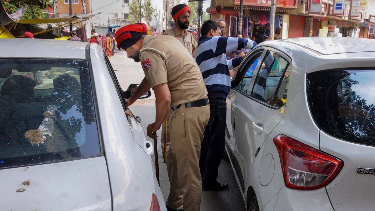 Police personnel check a vehicle amid a crackdown against 'Waris Punjab De' chief Amritpal Singh and his aides in Amritsar. Credit: PTI Photo