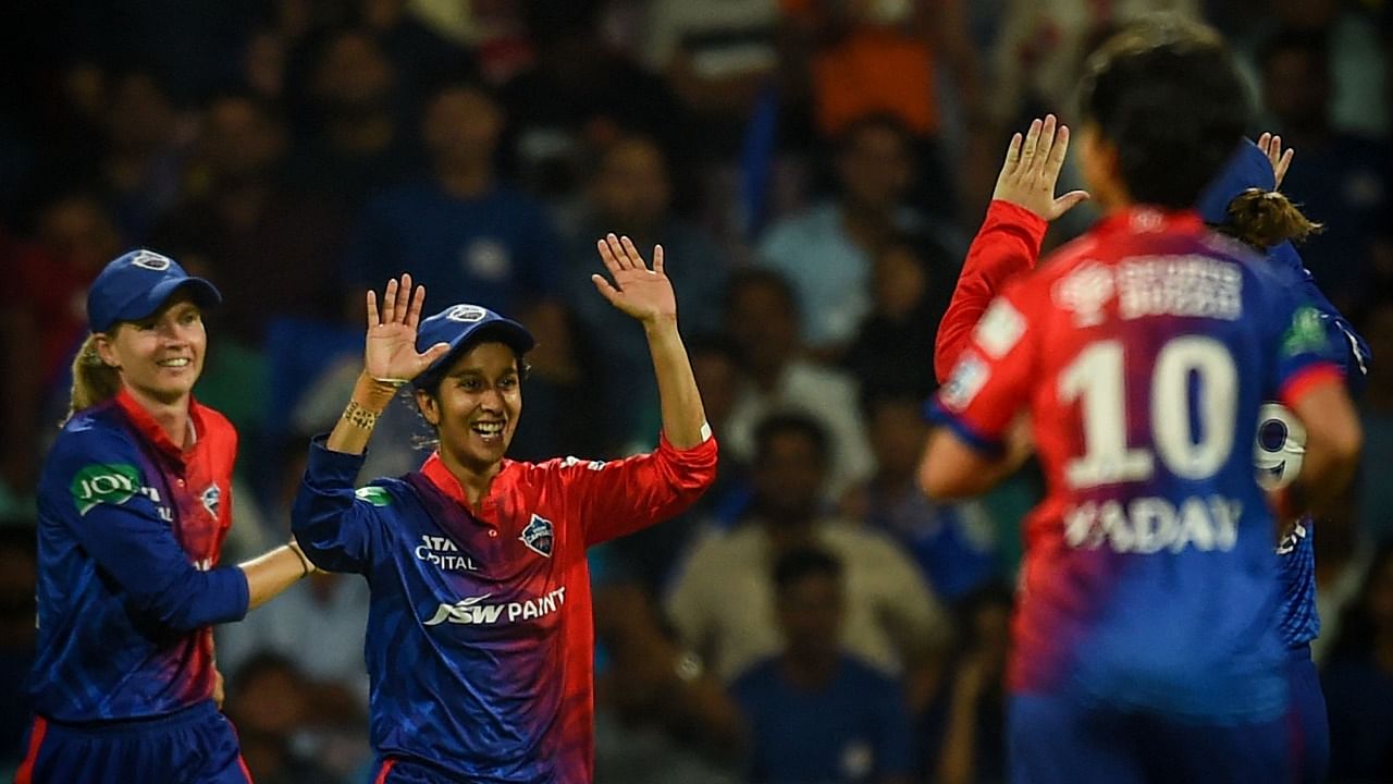 Delhi Capitals' Jemimah Rodrigues (2L) celebrates with teammates after taking the catch of Mumbai Indians' Harmanpreet Kaur. Credit: AFP Photo
