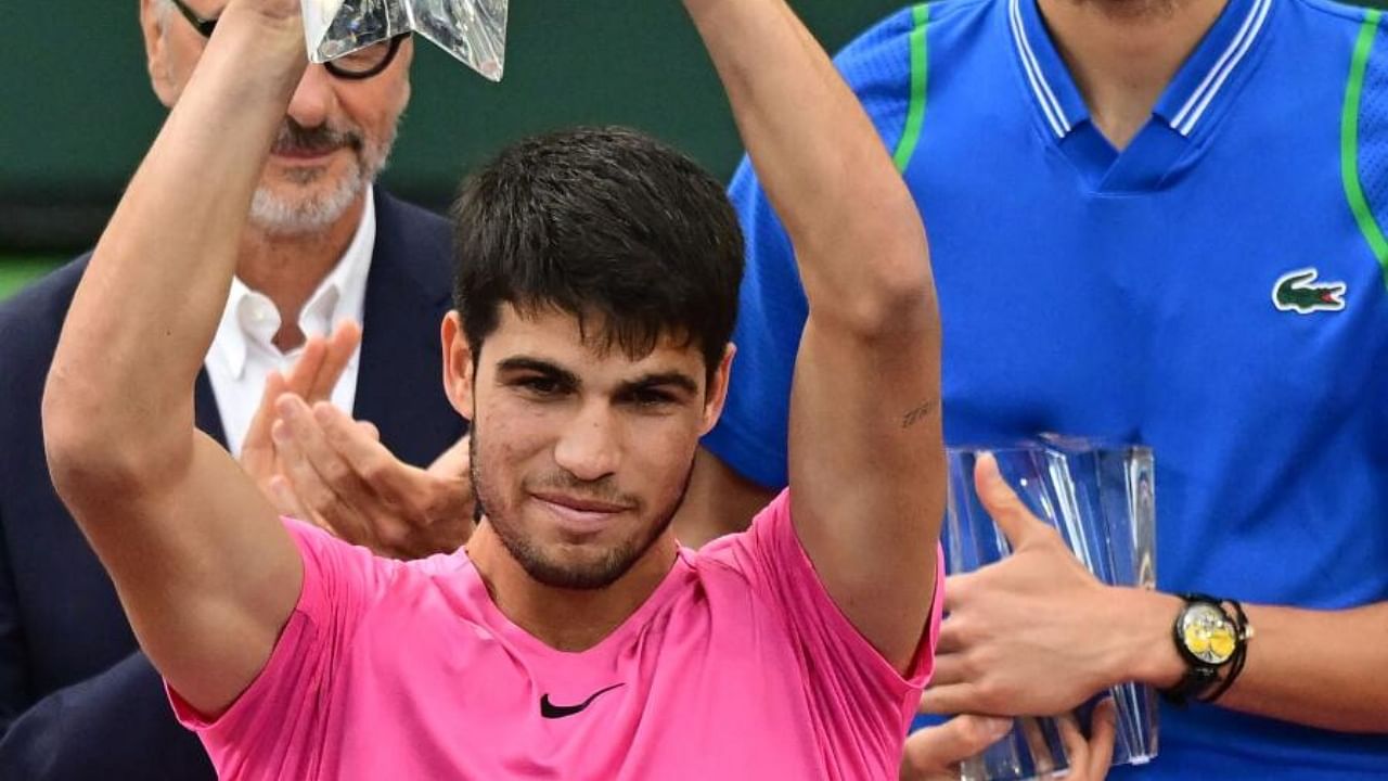 Carlos Alcaraz of Spain (L)lifts the championship trophy. Credit: AFP Photo