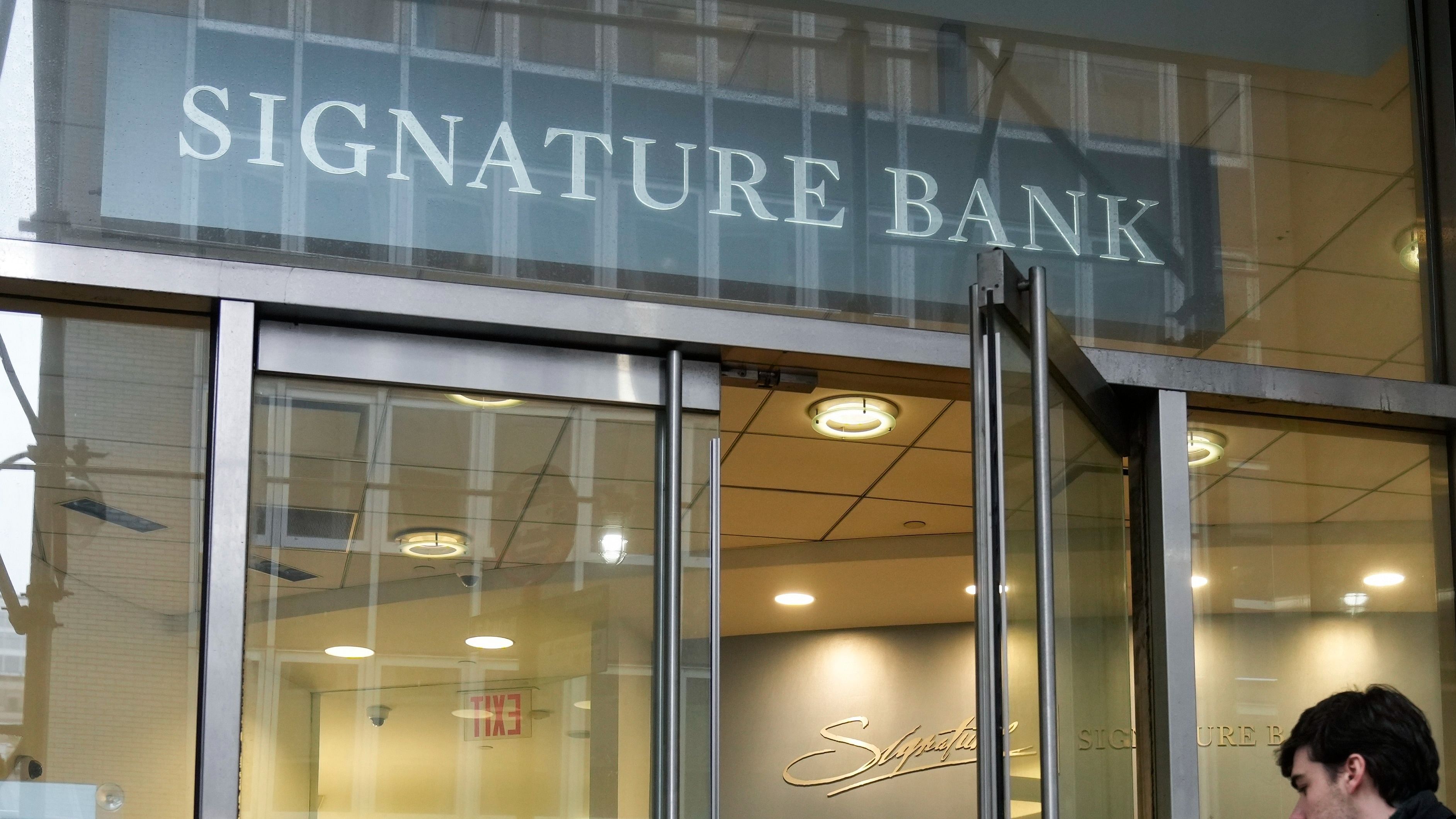 A woman leaves a branch of Signature Bank in New York. Credit: AP Photo