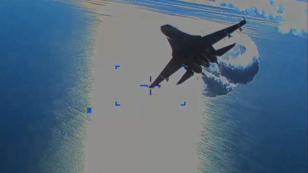 This handout image taken from video released by U.S. European Command (USEUCOM) on March 16, 2023, shows onboard footage from a U.S. Air Force MQ-9 drone as it is approached by a Russian SU-27 aircraft jettissoning fuel, over The Black Sea on March 14, 2023. Credit: AFP Photo