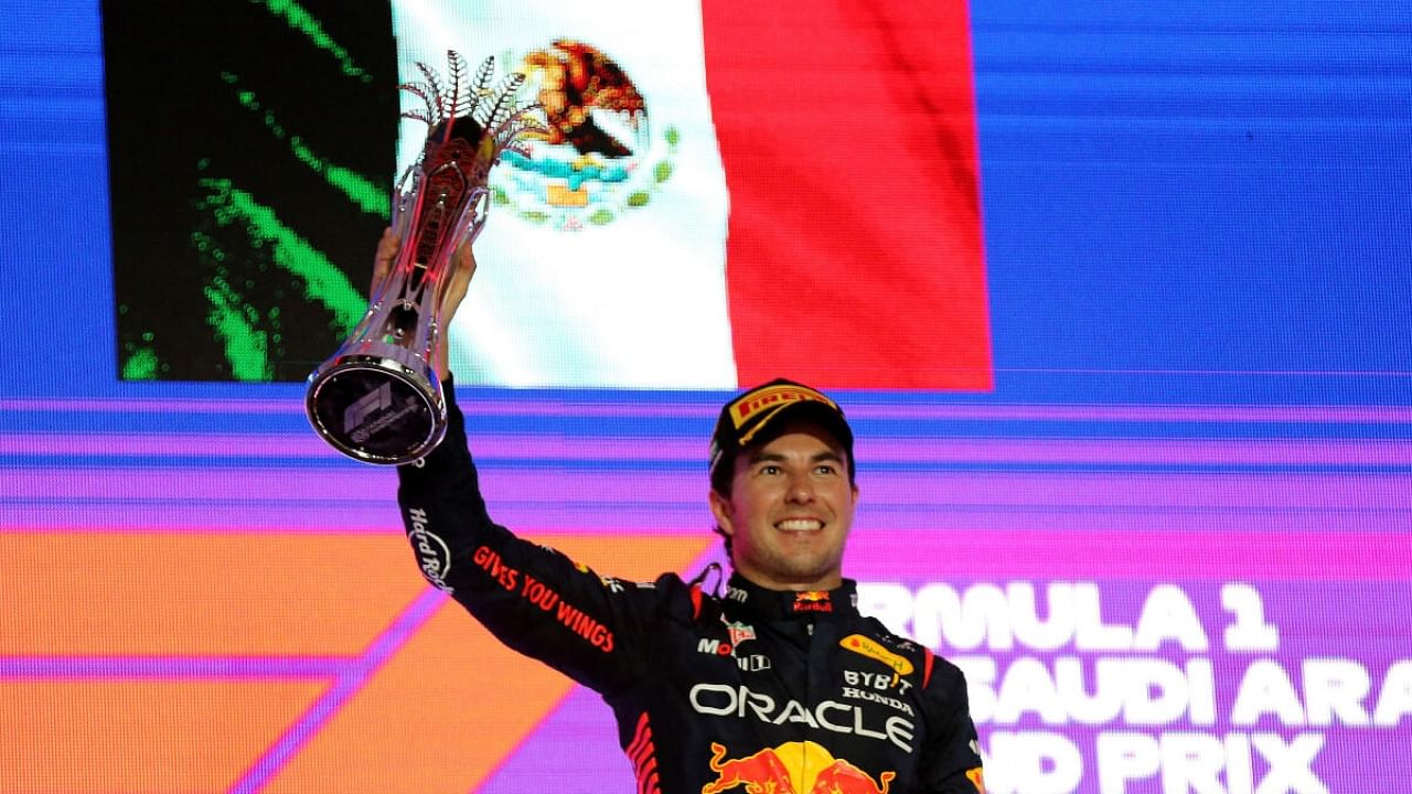 Red Bull's Sergio Perez celebrates with a trophy on the podium after winning the Saudi Arabian Grand Prix. Credit: Reuters Photo