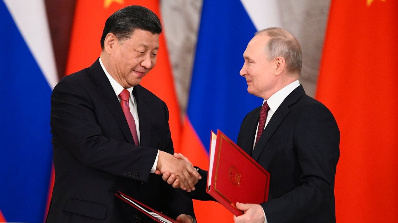 Russian President Vladimir Putin, right, and Chinese President Xi Jinping shake hands as they exchange documents during a signing ceremony following their talks at The Grand Kremlin Palace, in Moscow, Russia, Tuesday, March 21, 2023. Credit: PTI/AP Photo
