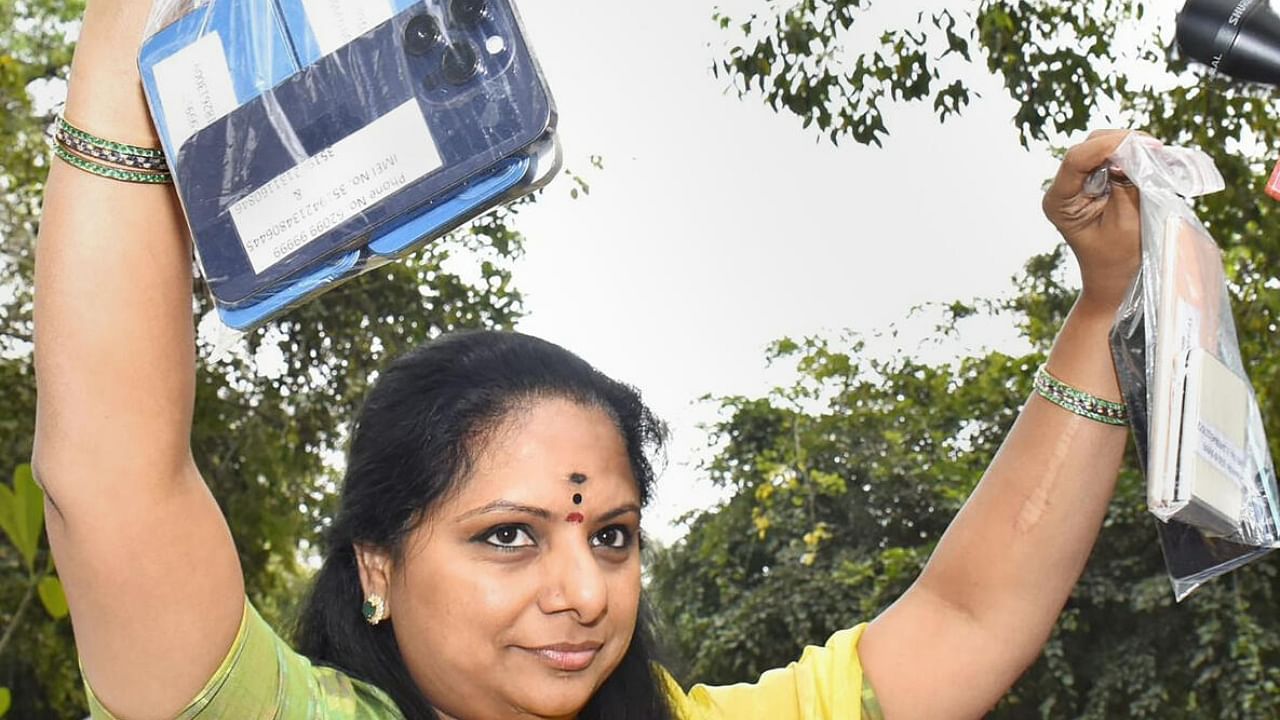 K Kavitha holds up her phones outside the ED office in Delhi. Credit: PTI Photo