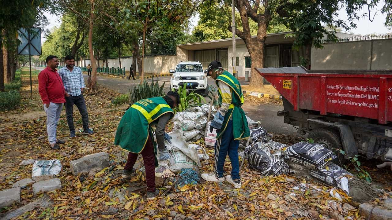 Workers during removal of security barricades outside the UK High Commission in New Delhi. Credit: PTI Photo