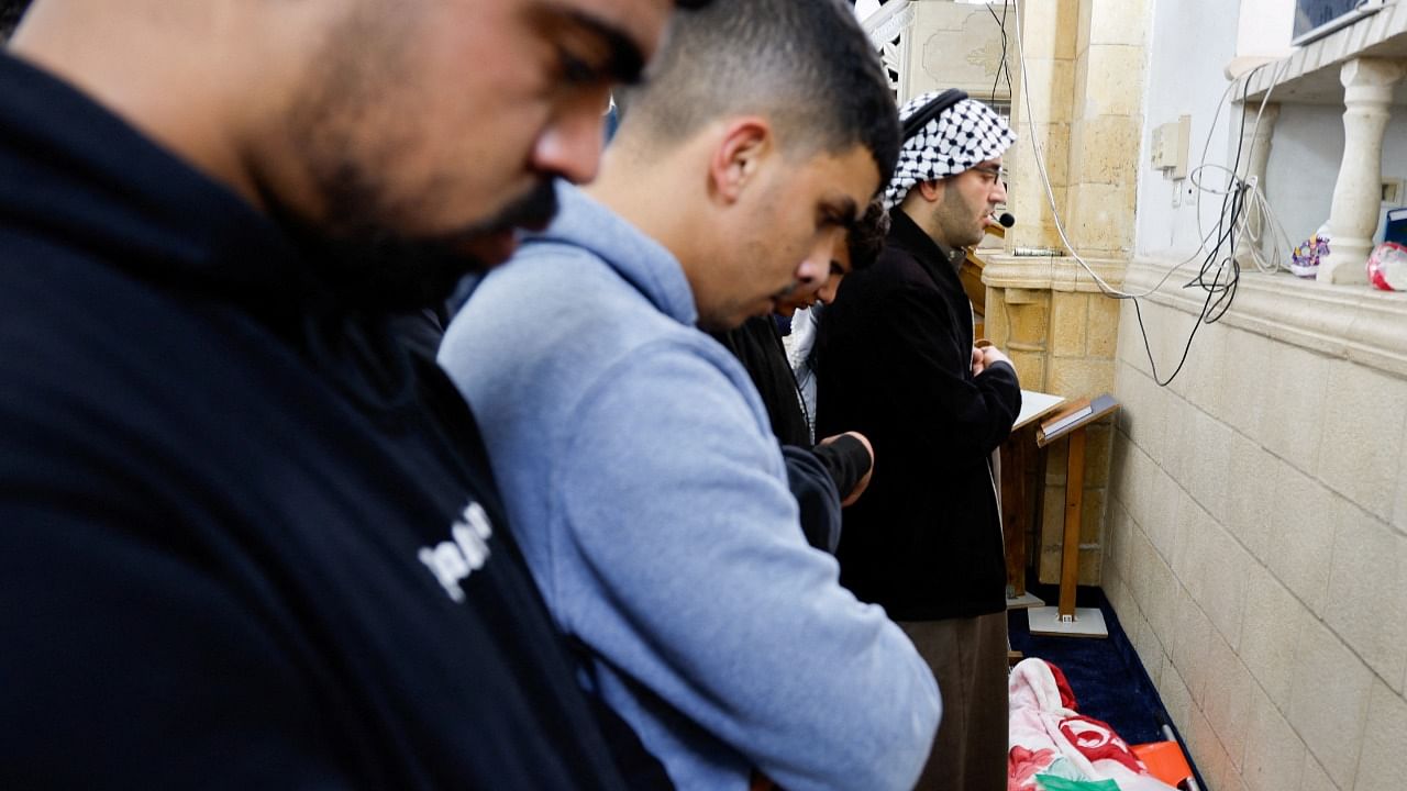 Mourners stand next to the body of a 25-year Palestinian Ameer abu Khadija. Credit: Reuters Photo