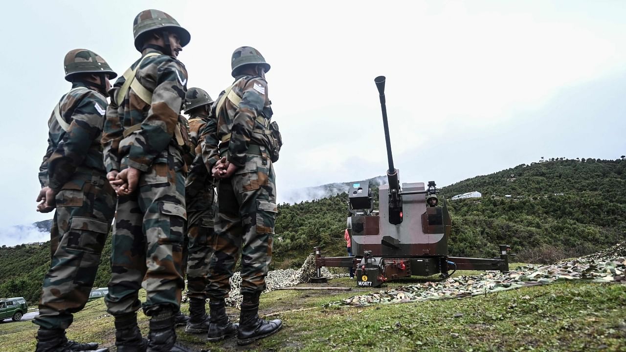 Indian Army soldiers stand next to an upgraded L70 anti aircraft gun in Tawang near the Line of Actual Control (LAC), in the northeast Indian state of Arunachal Pradesh on October 20, 2021. Credit: AFP File Photo