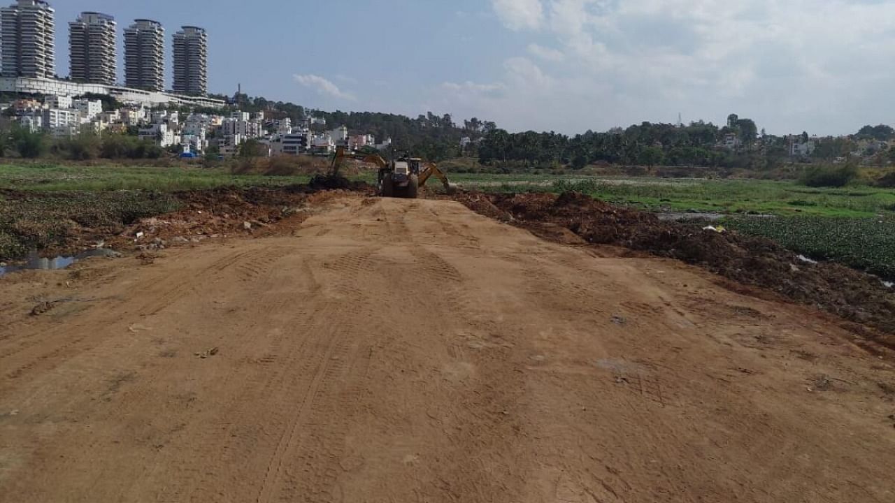 In a damage-control exercise, the BBMP on Thursday promised to clear truckloads of mud and debris it dumped into Hosakerehalli lake in the last four months. Credit: Special Arrangement