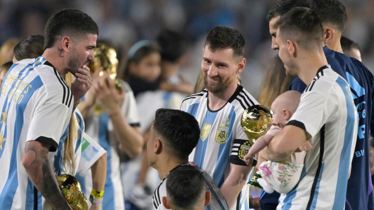Argentina's midfielder Rodrigo De Paul (L) and forward Lionel Messi (C) talk with teammates during a recognition ceremony for the World Cup winning players, following the friendly football match between Argentina and Panama. Credit: AFP Photo