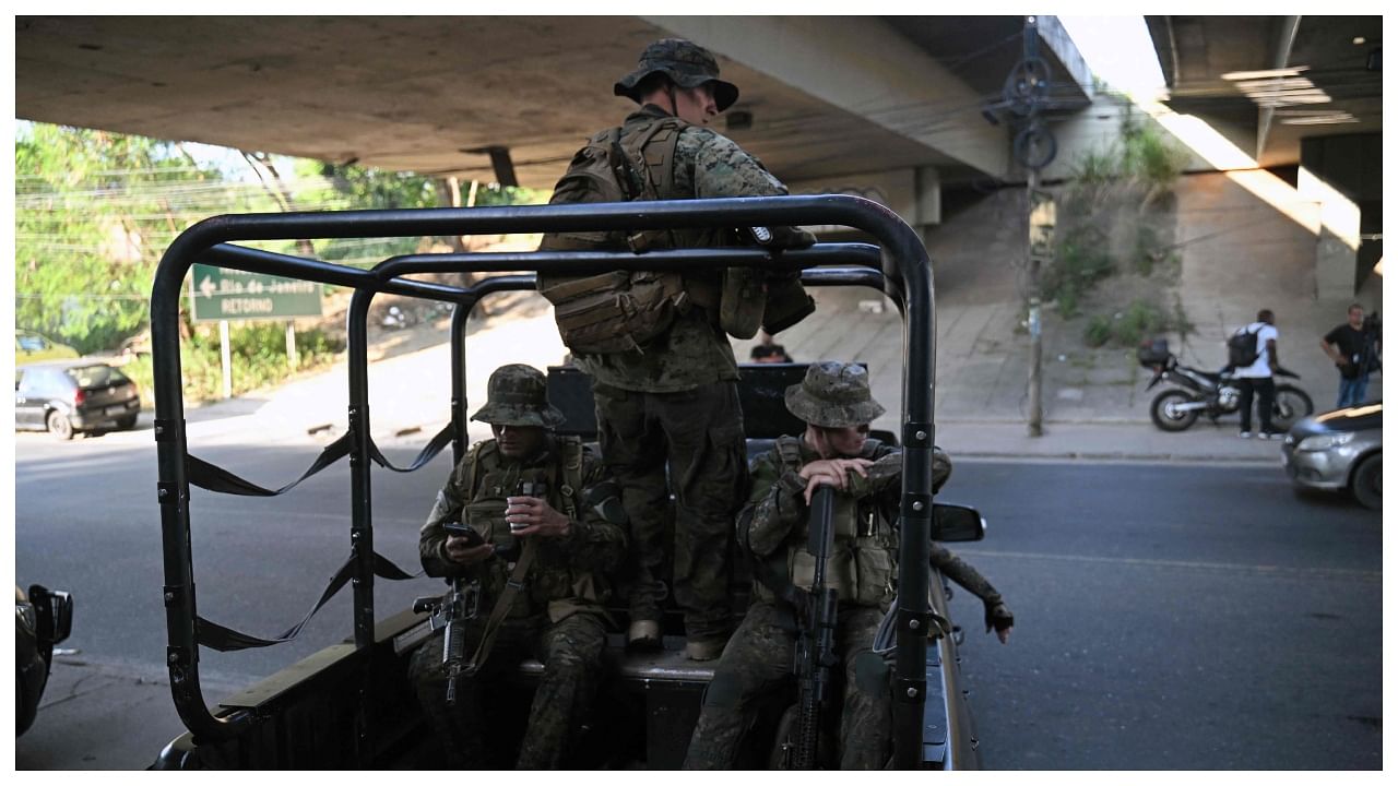 Militarized police members stand guard during a police operation at the Salgueiro Complex, in Sao Goncalo, Rio de Janeiro. Credit: AFP Photo