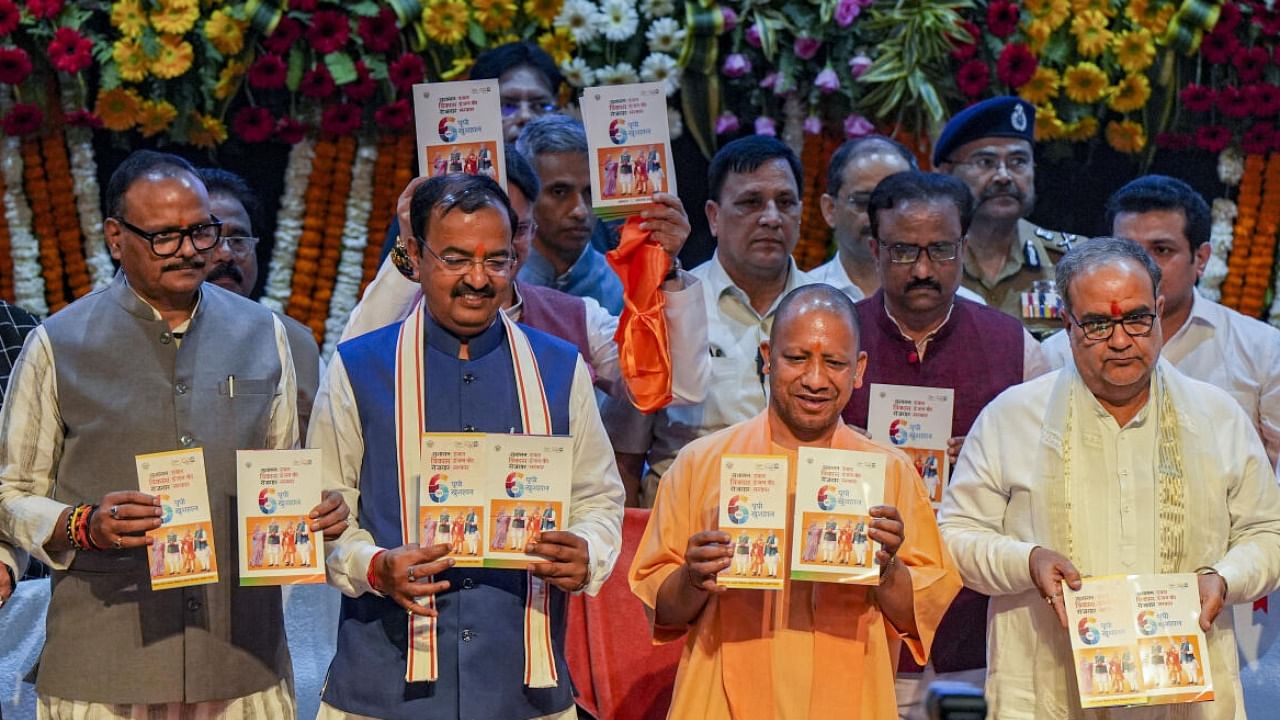 UP CM Yogi Adityanath with Deputy CMs Brajesh Pathak and Keshav Prasad Maurya and UP BJP President Bhupendra Chaudhary to mark completion of one year of party's second consecutive term in Lucknow. Credit: PTI Photo
