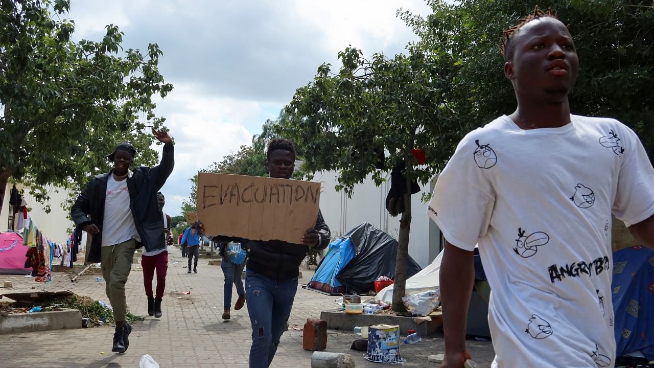 African migrants gesture and carry banners during a protest asking for evacuation from Tunisia, outside the International Organization for Migration (IOM), in Tunis, Tunisia March 22, 2023. Credit: Reuters Photo