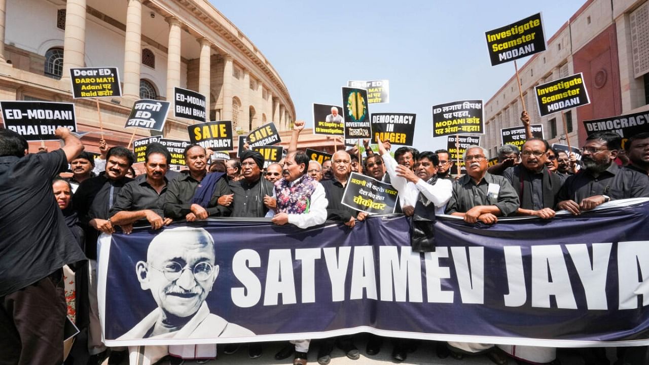 Opposition MPs, wearing black over the disqualification of Congress leader Rahul Gandhi from Lok Sabha, protest over the Adani Group issue at Parliament House complex during Budget Session, in New Delhi, Monday, March 27, 2023. Credit: PTI Photo