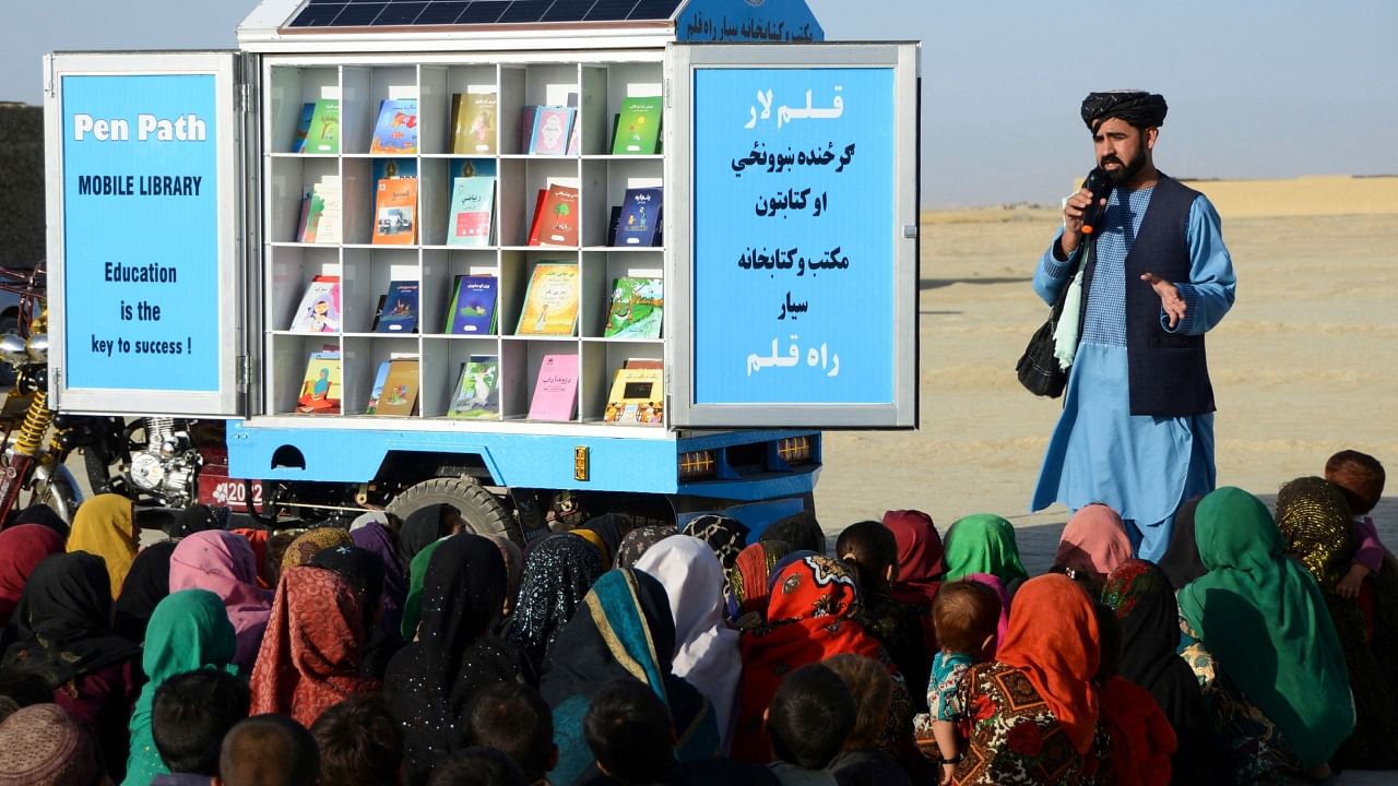 In this photograph taken on May 17, 2022, Matiullah Wesa, head of PenPath and advocate for girls' education in Afghanistan, speaks to children during a class next to his mobile library in Spin Boldak district of Kandahar Province. Credit: AFP File Photo