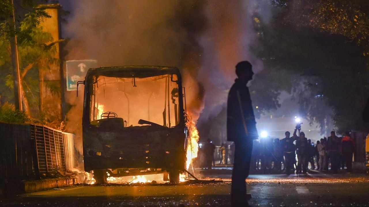 A bus set ablaze by protestors against the Citizenship Amendment Act at Mathura Road, in New Delhi. Credit: PTI File Photo