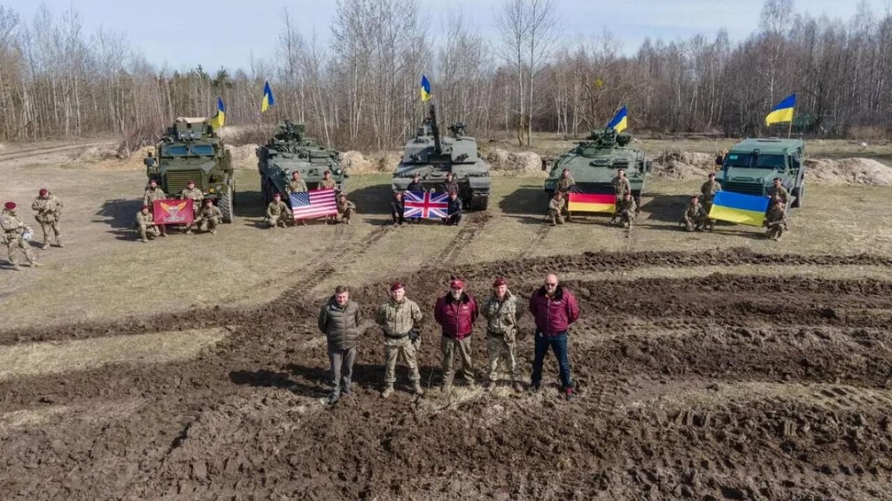 Ukraine's Defence Minister Oleksii Reznikov and Commander of the Air Assault Forces Maksym Myrhorodskyi pose for a picture in front of British Challenged 2 main battle tank, U.S. Stryker and Cougar armoured personnel carriers and German Marder infantry fighting vehicle, amid Russia's attack on Ukraine, in an unknown location in Ukraine, in this handout picture released March 27, 2023. Press Service of the Defence Ministry of Ukraine/Handout via REUTERS