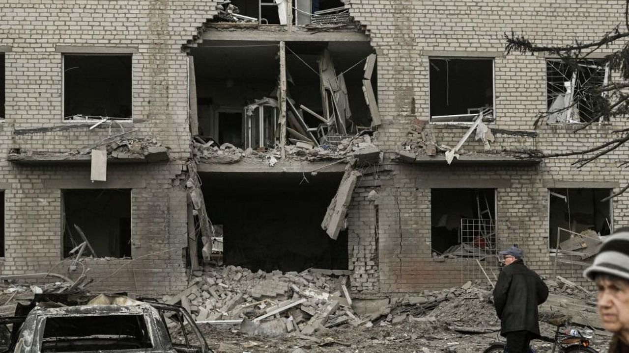 People walk in front of a destroyed building after a deadly strike in the city of Sloviansk, on March 27, 2023. Credit: AFP Photo