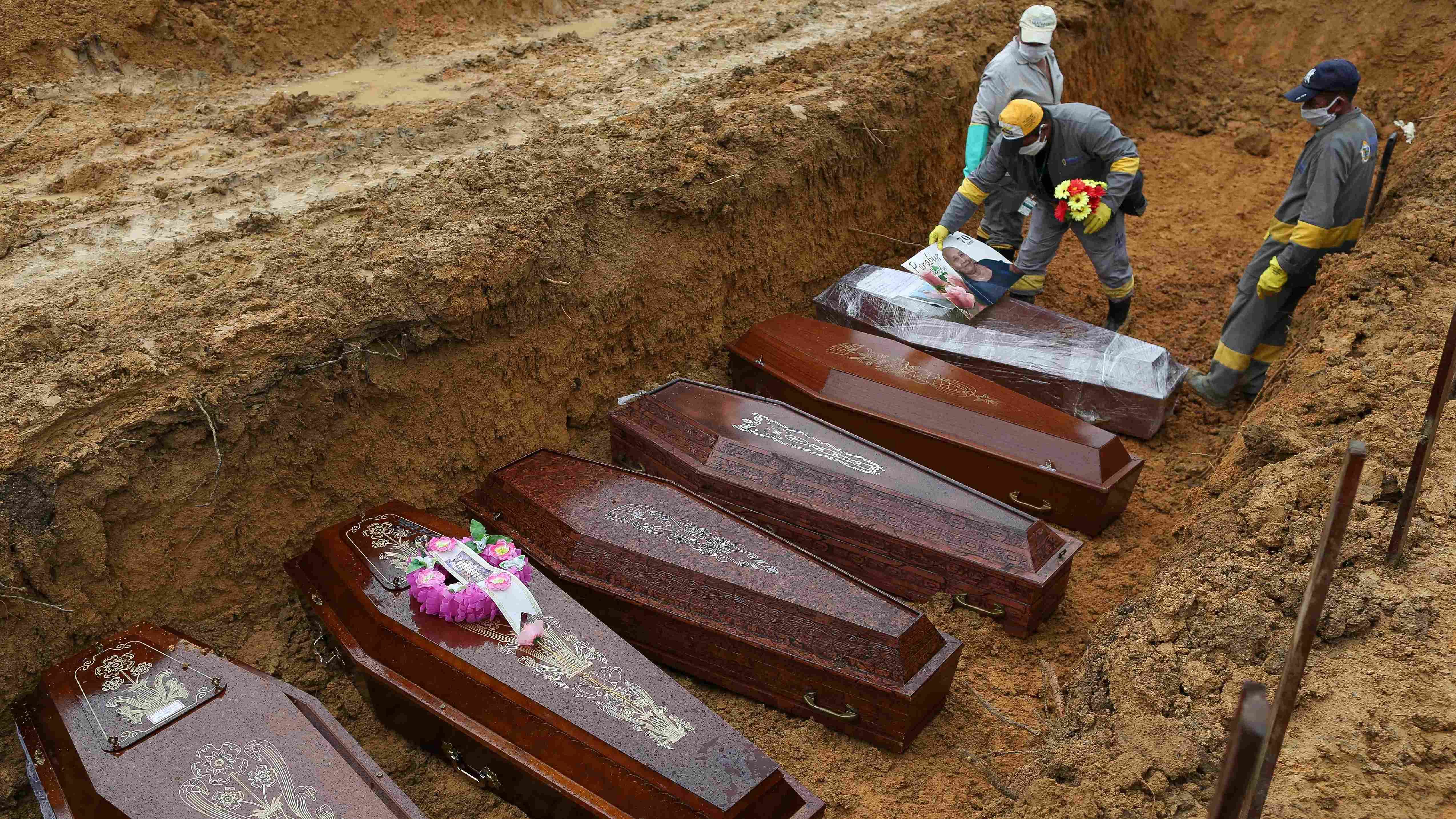  In this file photo taken on May 06, 2020 cemetery workers prepare the coffins to be buried in a mass grave at the Nossa Senhora cemetery in Manaus, Amazon state, Brazil, amid the COVID-19 coronavirus pandemic. - Three years after the first case of Covid-19 was recorded in Brazil -the world's second-most stricken by the pandemic- the country reached 700,000 deaths caused by this virus the Health Ministry said, on March 28, 2023. Credit: AFP Photo