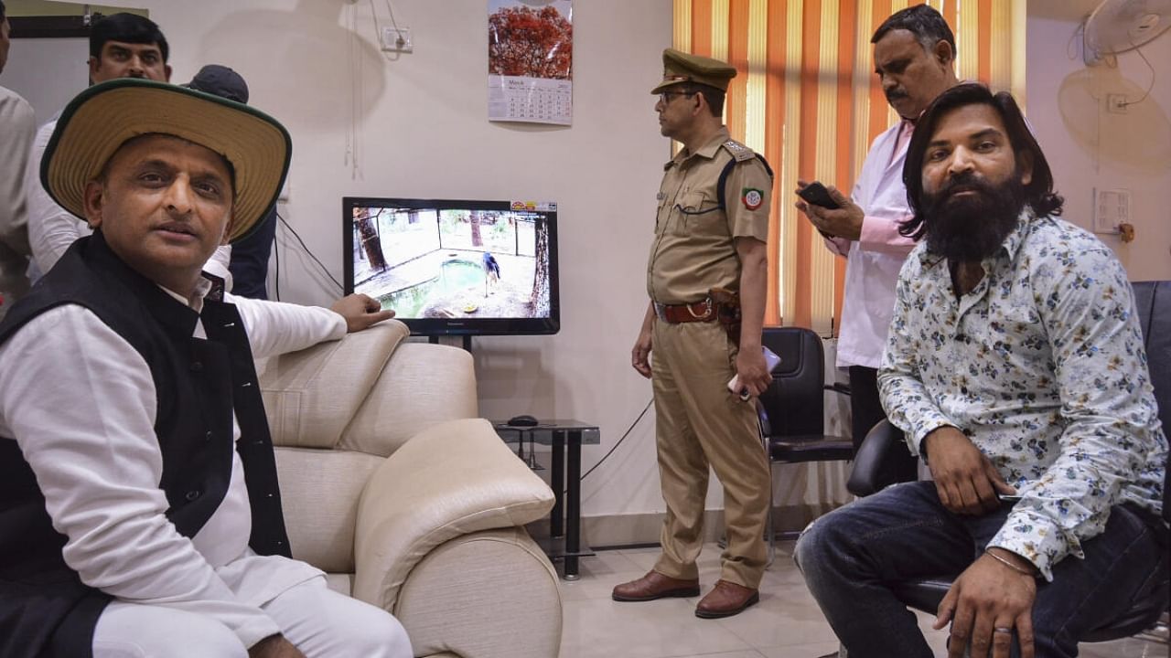 Samajwadi Party Chief Akhilesh Yadav and Amethi's Mohammad Arif, who befriended a 'Sarus' crane, see the quarantine 'Sarus' via CCTV at the Zoological Park, in Kanpur. Credit: PTI Photo