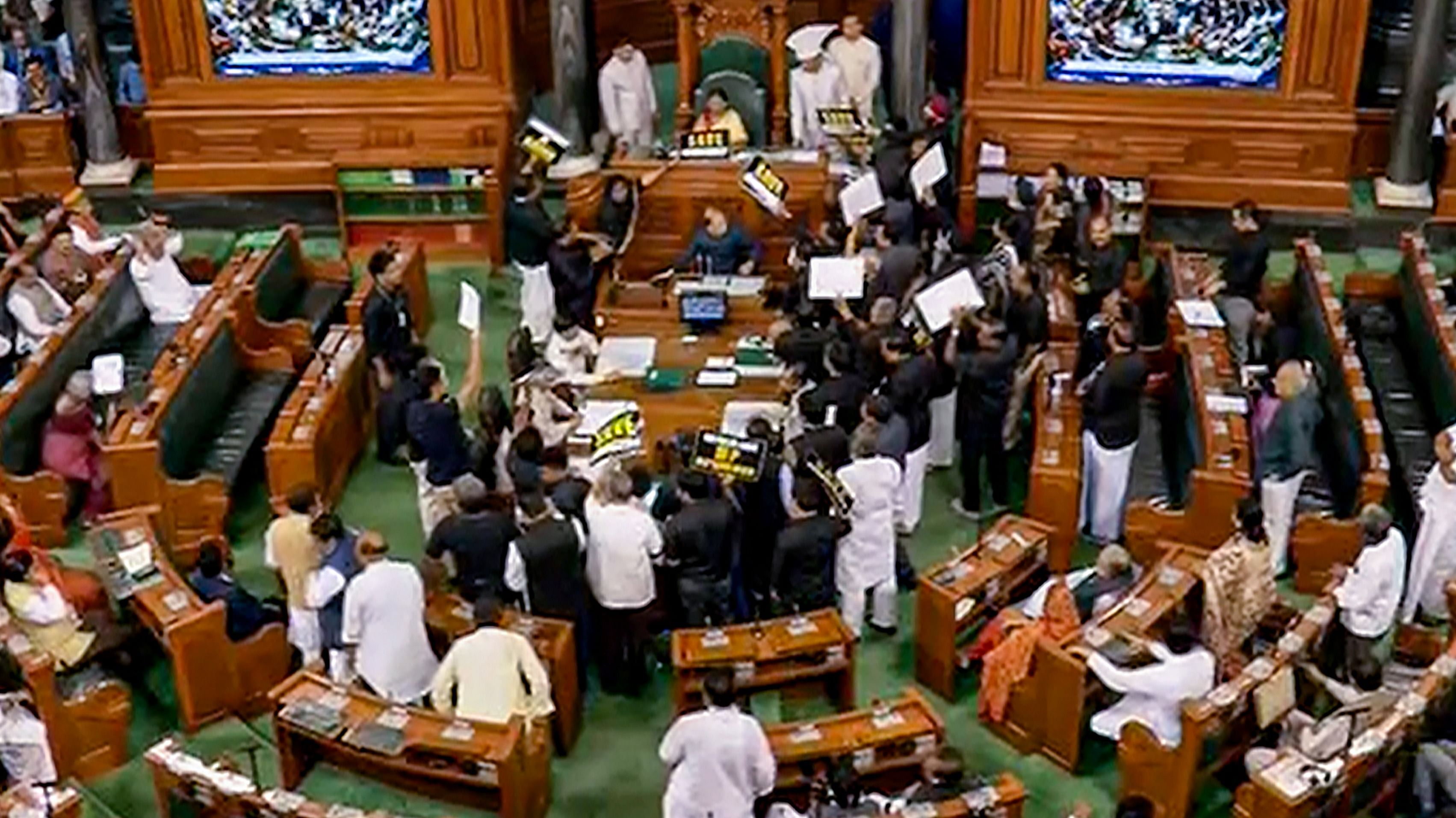  Opposition MPs, wearing black over the disqualification of Congress leader Rahul Gandhi from Lok Sabha, protest in the well of the House during Budget Session of Parliament, in New Delhi, Tuesday, March 28. Credit: PTI Photo