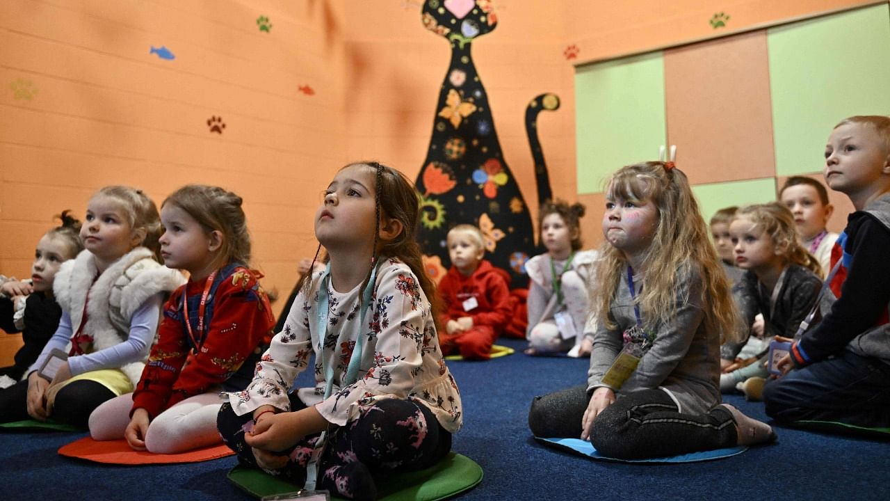 Children play in an air-raid shelter in the cellar of a kindergarten in Kyiv on March 20, 2023. Credit: AFP Photo