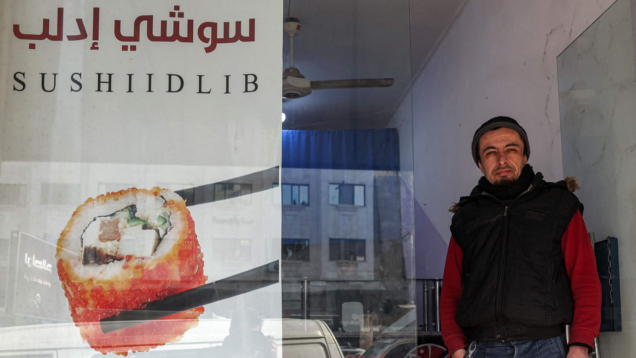 Islam Shakhbanov, a 37-year-old fighter from Russia's Muslim-majority Dagestan republic, stands at the entrance of his sushi restaurant in Syria's rebel-held northwestern city of Idlib. Credit: AFP Photo