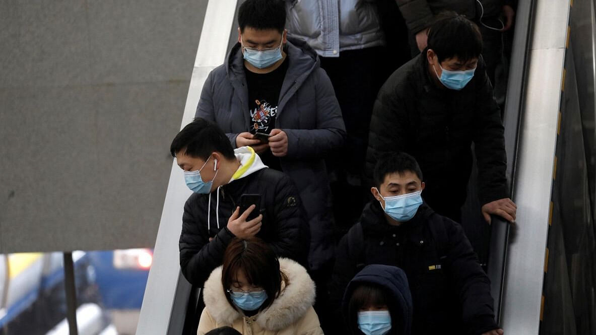 People wearing face masks commute in a subway station in Beijing, China. Credit: Reuters Photo