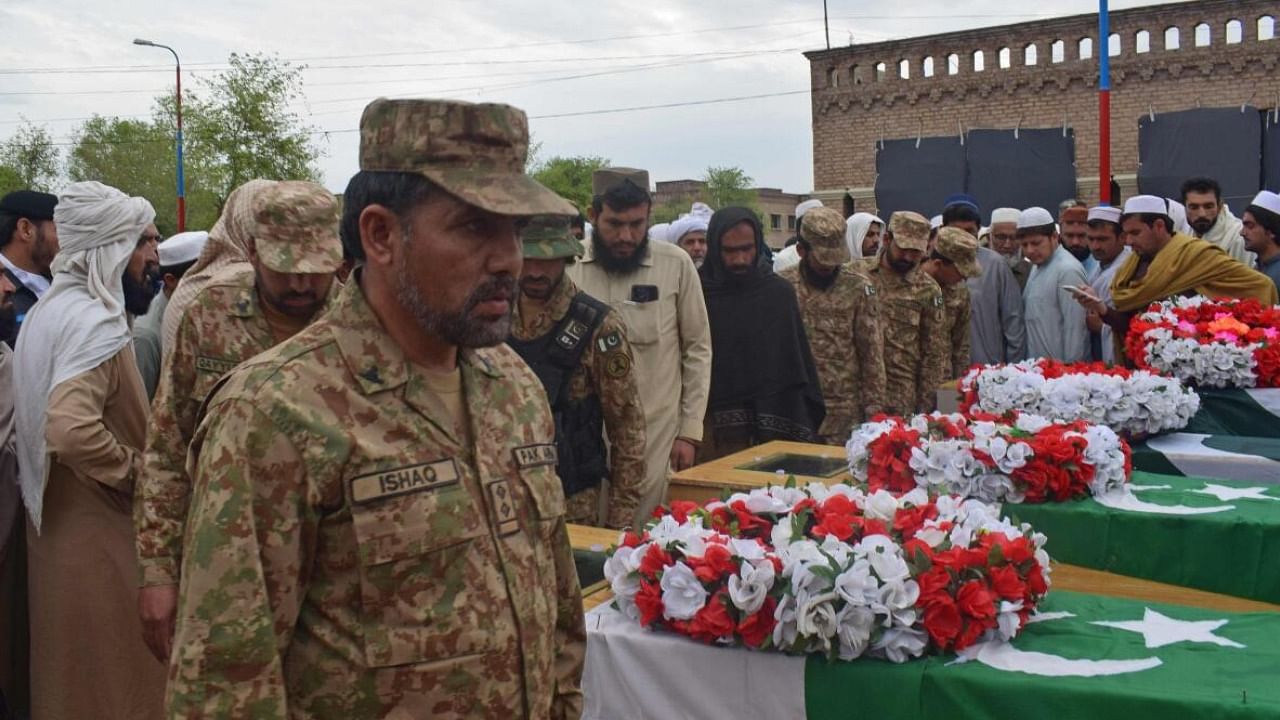 Relatives and security officials gather around the coffins of policemen who were killed by a roadside bomb in Lakki Marwat district of Khyber Pakhtunkhwa province. Credit: AFP Photo