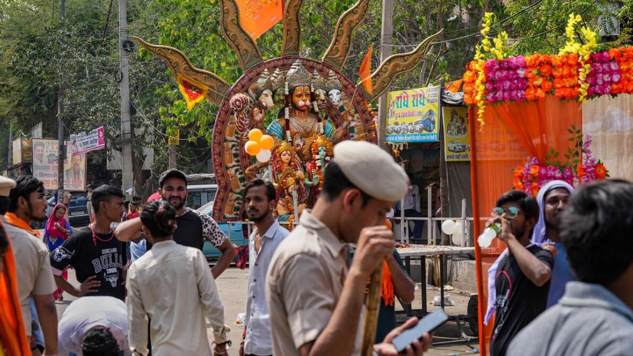 A police man guards as locals participate in a Ram Navmi procession organised by a group at Jahangirpuri