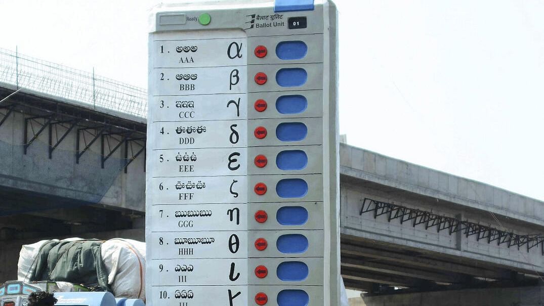 Vijayawada: Pedestrians walk past a replica of Electronic Voting Machine (EVM) installed by the Election Commission of India to create awareness about voting at Benz circle, in Vijayawada, Saturday, March 16, 2019. Credit: PTI Photo