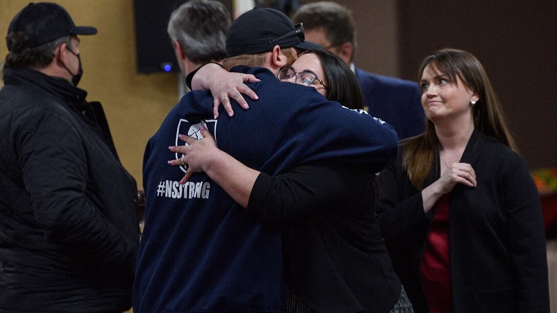 Nick Beaton, whose pregnant wife was a victim in the mass killing, is hugged by Darcy Dobson, daughter of one of the victims, before the Mass Casualty Commission delivers its final report into the April 2020 mass shootings, when a gunman who at one point masqueraded as a police officer caused country's worst mass shooting during a 12-hour rampage, in Truro, Nova Scotia, Canada, March 30, 2023. Credit: Reuters Photo