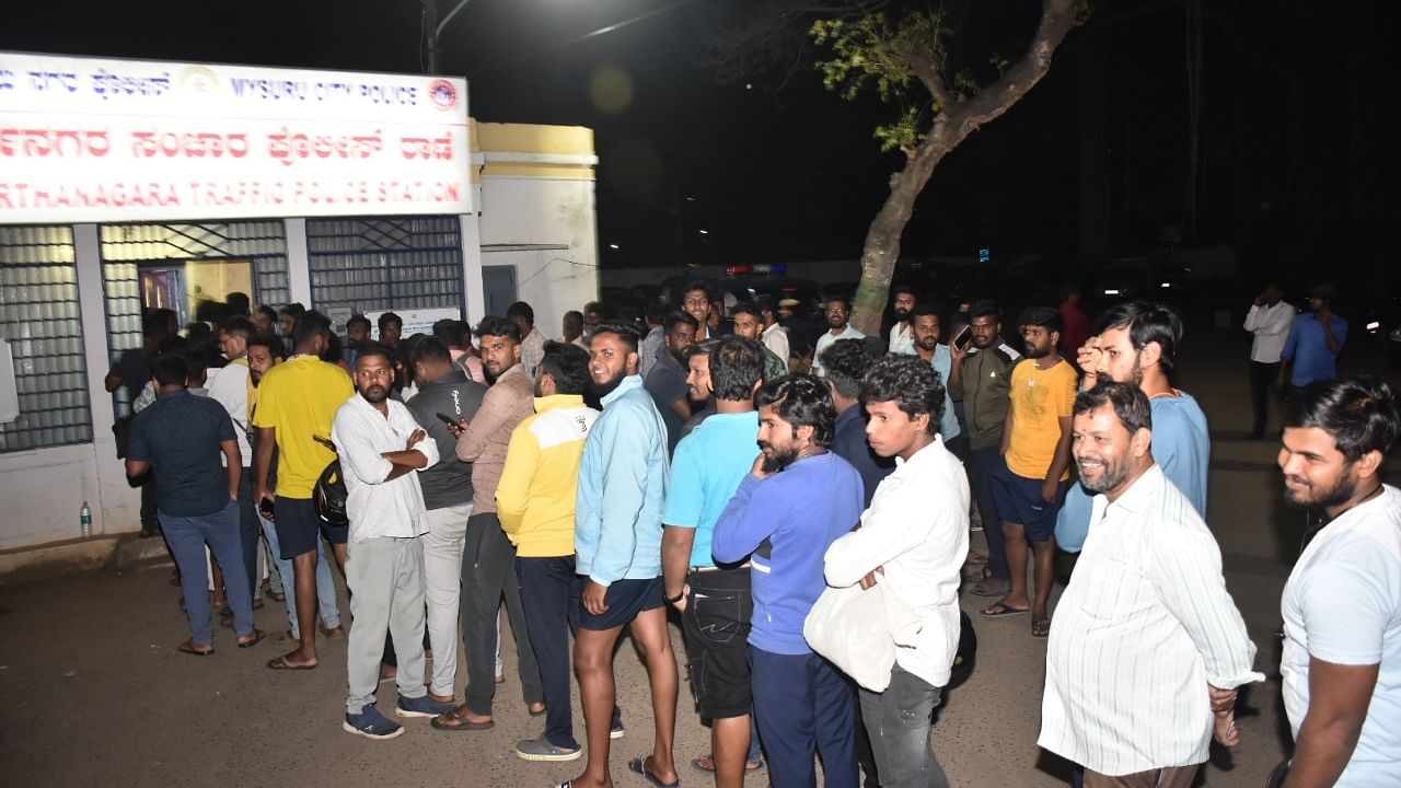 People stand in a queue before a traffic police station in Mysuru to clear pending traffic fines for e-challans generated for violation of traffic rules, during a 50% discount offered by the government. Credit: DH File Photo