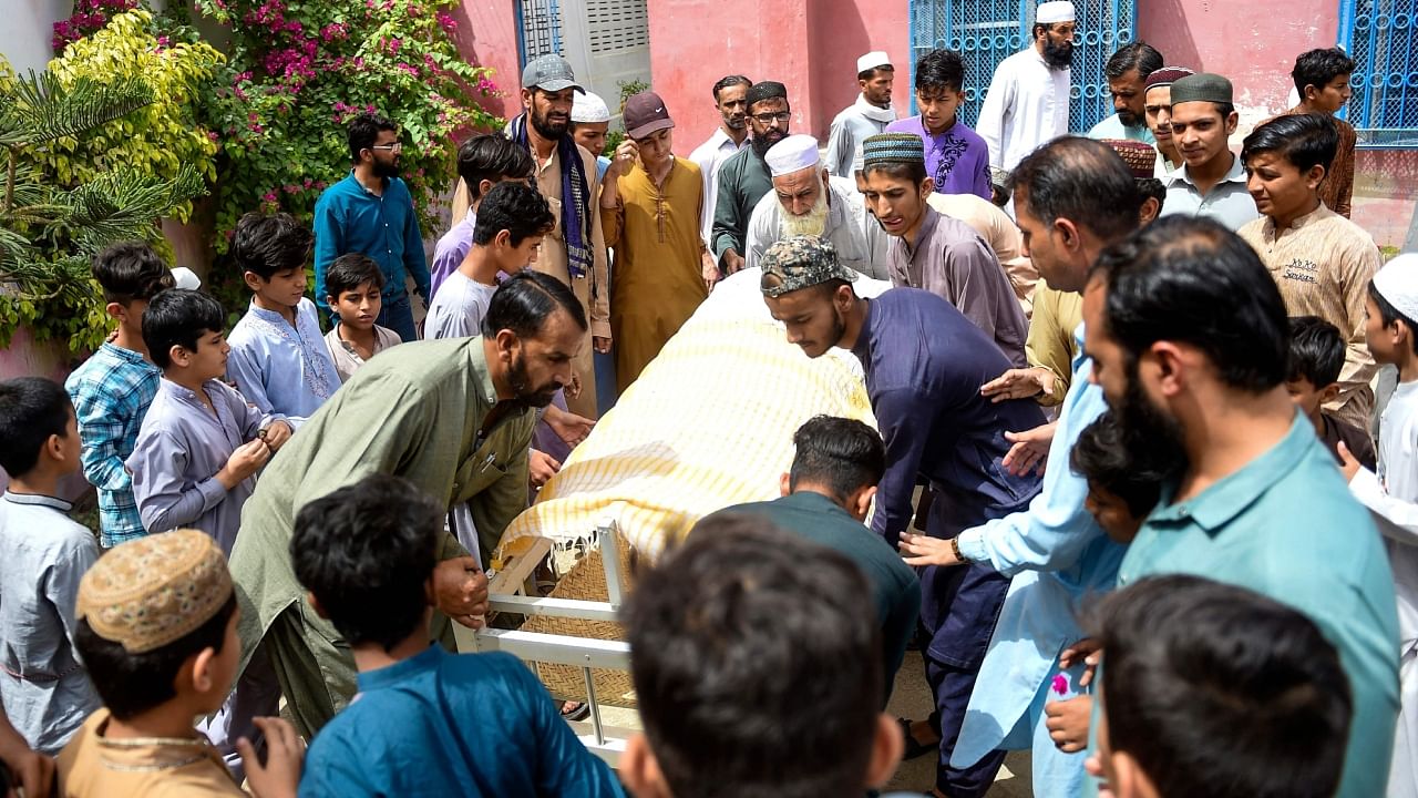 Mourners carry the coffin of a stampede victim for his funeral in Karachi on April 1, 2023. Credit: AFP Photo