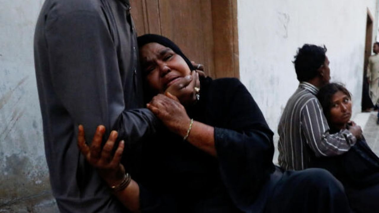 People mourn the death of a relative, who was killed with others in a stampede during handout distribution, in Karachi. Credit: Reuters Photo