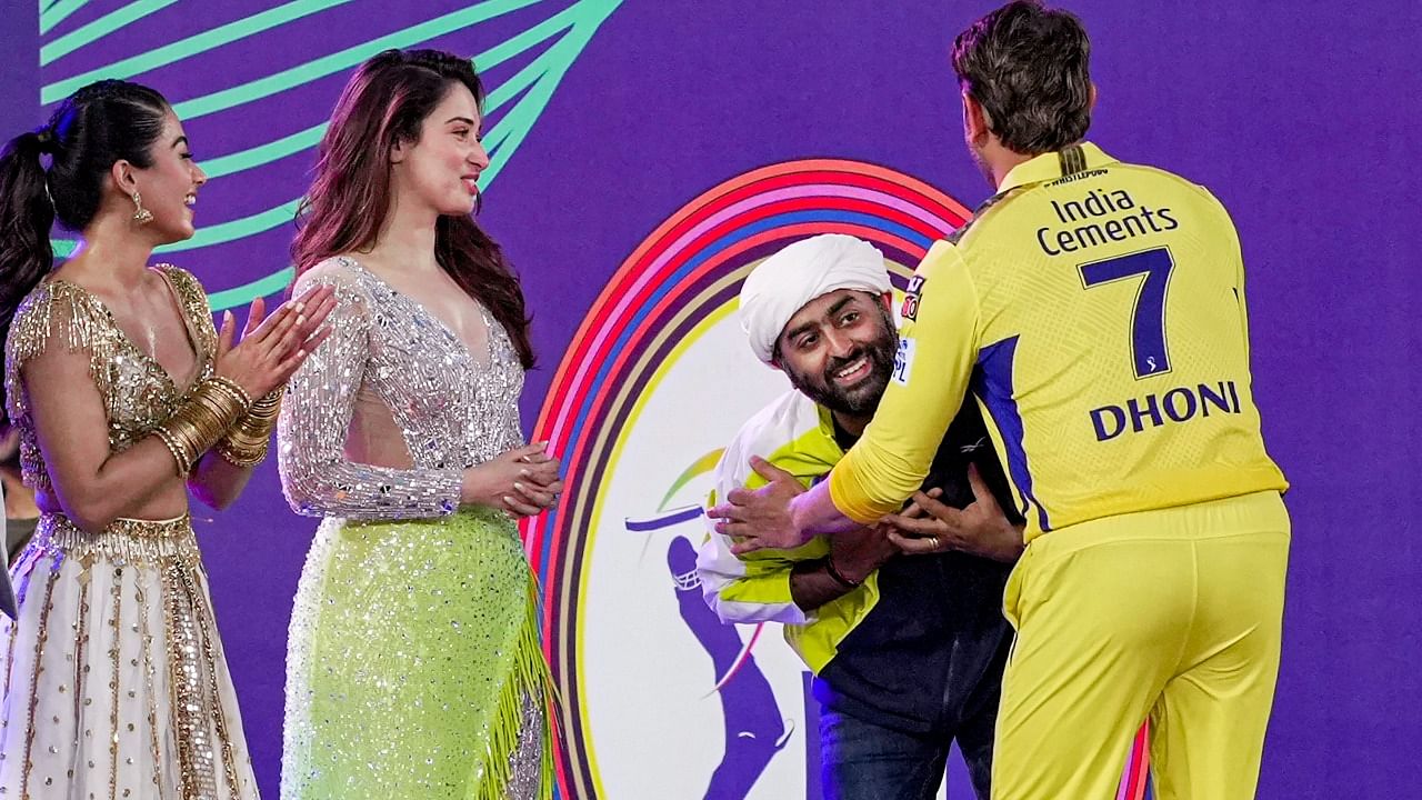Chennai Super Kings captain Mahendra Singh Dhoni being greeted by singer Arijit Singh as actors Rashmika Mandanna and Tamannaah Bhatia look on during the IPL 2023 opening ceremony. Credit: PTI Photo
