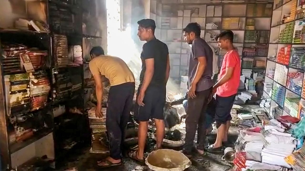 People gather at a burnt shop after a clash broke out between two groups during Ram Navami procession, in Nalanda district, Sunday, April 2, 2023. Credit: PTI Photo