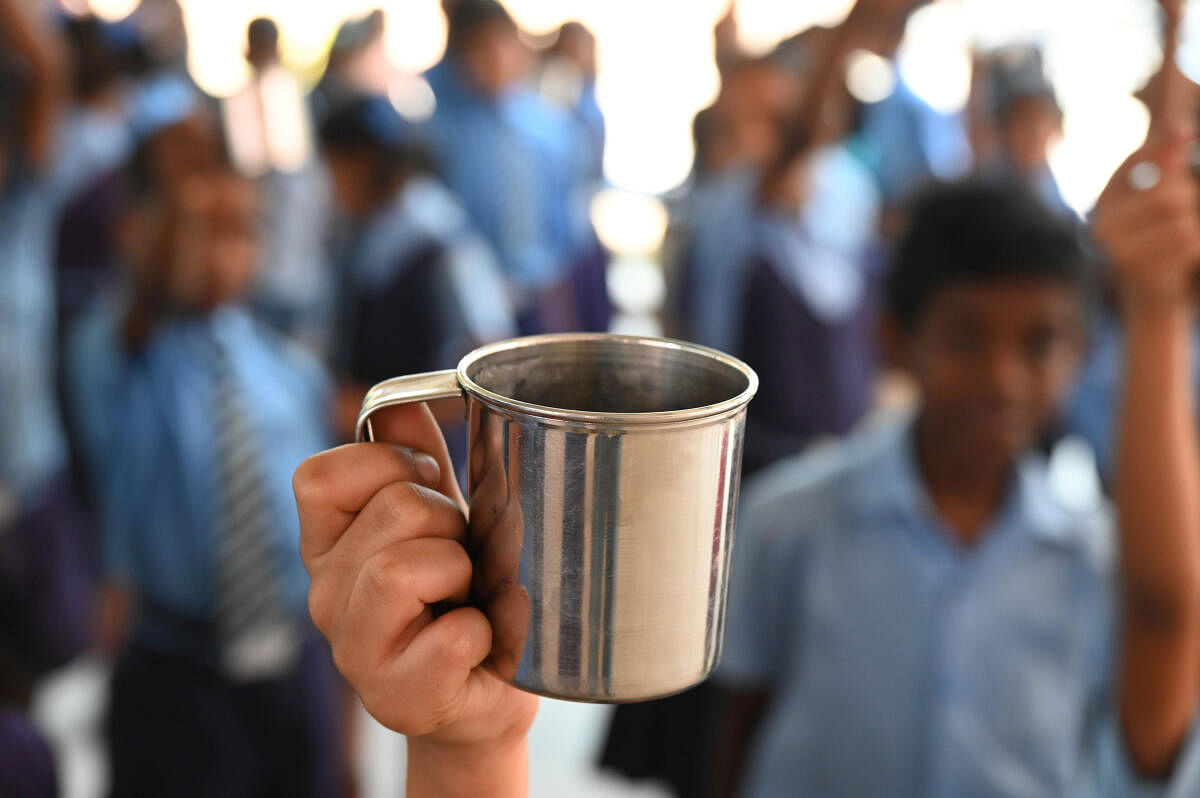 Government schools in 11 districts of Karnataka have not been supplied milk since January. Children pictured with empty cups, awaiting milk, in Bengaluru. Credit: DH Photo/B K Janardhan