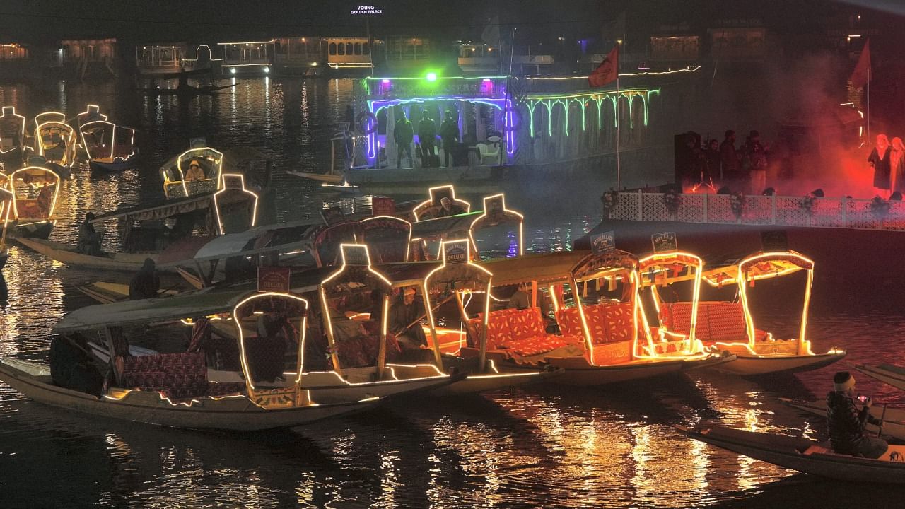 The moving shikaras (boats) with their illuminated lights shine like jewels in the Dal Lake. The move has increased the working hours of shikara owners, which means more business for them. Credit: PTI Photo