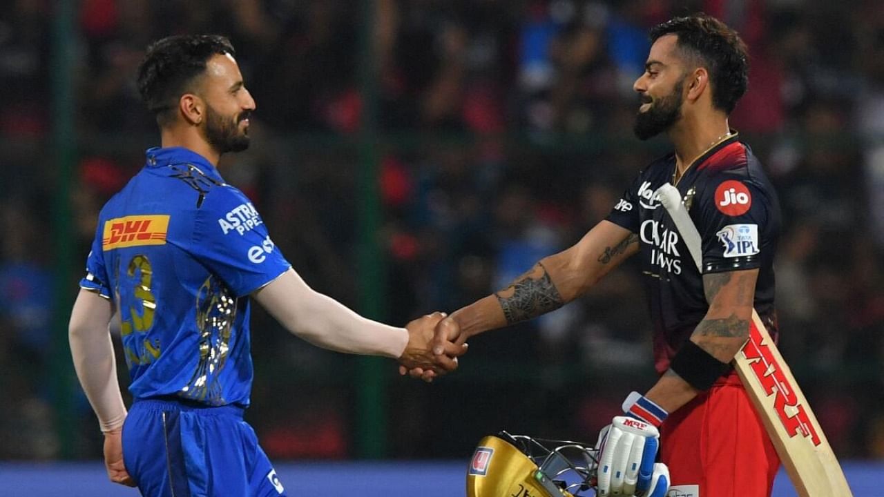 Mumbai Indians' Ramandeep Singh (L) greets Royal Challengers Bangalore's Virat Kohli at the end of the Indian Premier League (IPL) Twenty20 cricket match between Royal Challengers Bangalore and Mumbai Indians at the M Chinnaswamy Stadium in Bengaluru on April 2, 2023. 