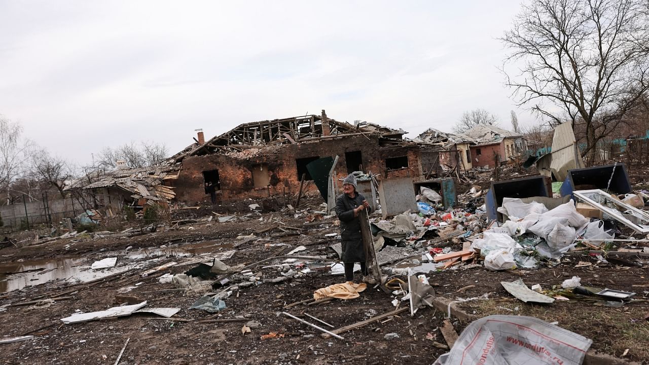 A person collects scrap metal, in the aftermath of deadly shelling of residential buildings, as Russia's invasion of Ukraine continues, in Kostiantynivka. Credit: Reuters Photo