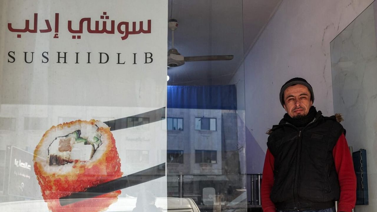  Islam Shakhbanov stands at the entrance of his sushi restaurant in Syria's rebel-held northwestern city of Idlib. Credit: AFP Photo