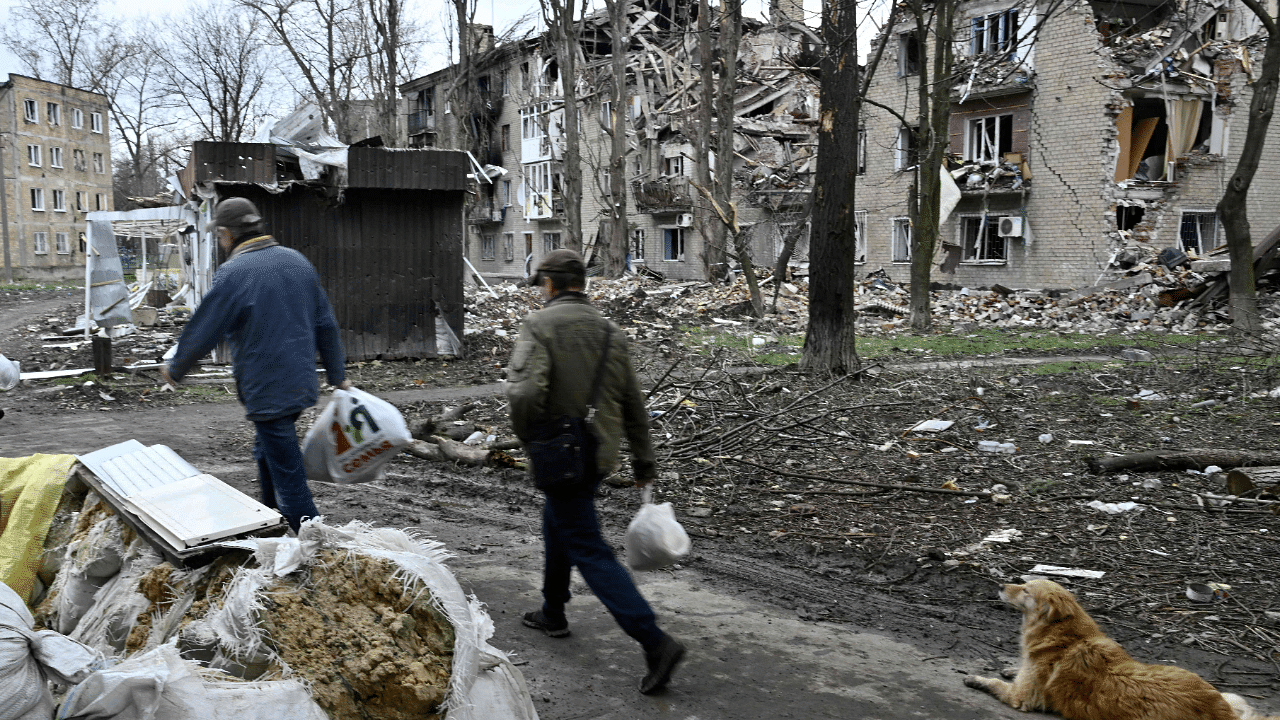 Local residents walk past a destroyed residential building in the frontline town of Avdiivka, Donetsk region. Credit: AFP Photo